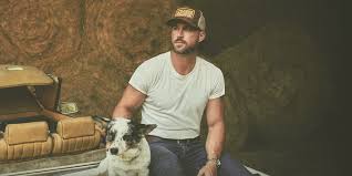 Riley Green sitting with a dog